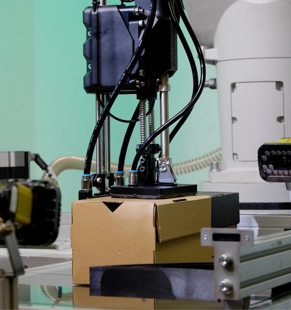 Robot Nomagic do podnoszenia pudełek na buty trzymający pudełko na buty