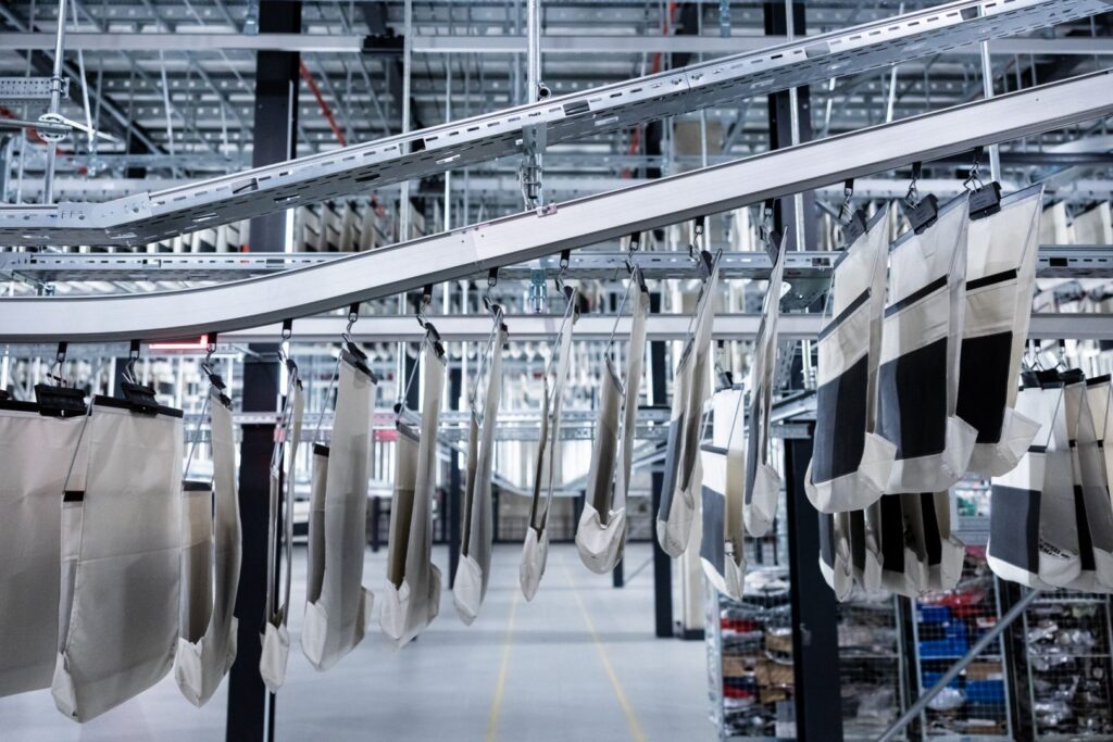 collection bags within an asos warehouse hanging from a conveyor